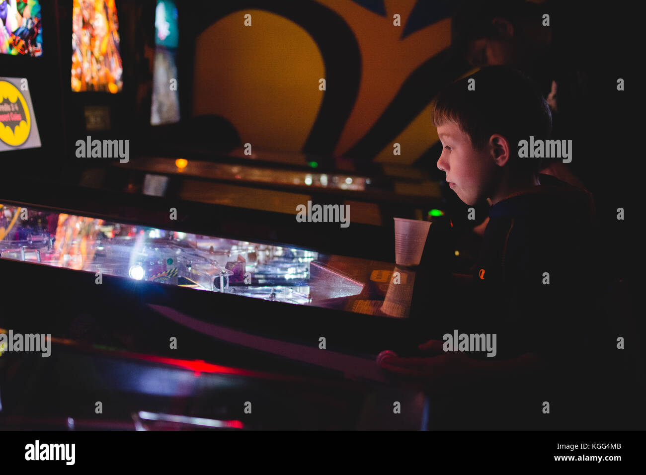 A young boy plays a game of pinball at a traditional arcade in upstate