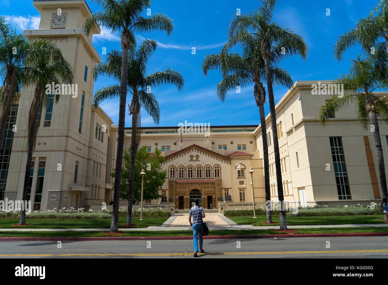 Male walking across Glassell Street to the Chapman University Fowler School of Law building and the Donald P Kennedy Hall Stock Photo