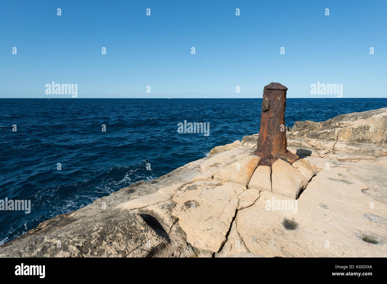 Old bollard on rocky coast of Valletta (Malta) Stock Photo