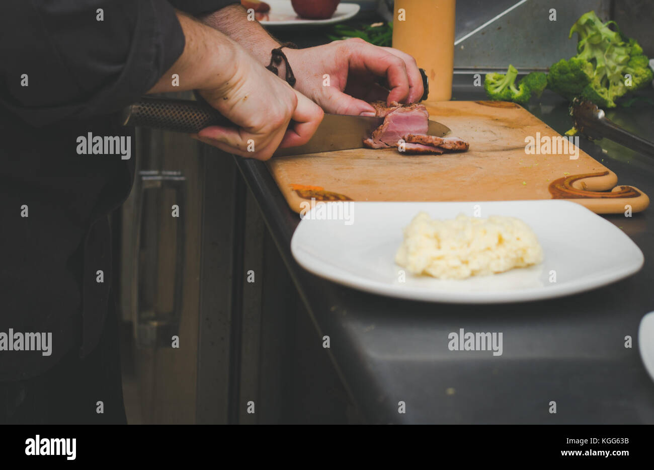 A chef prepares food in the kitchen of a restaurant Stock Photo