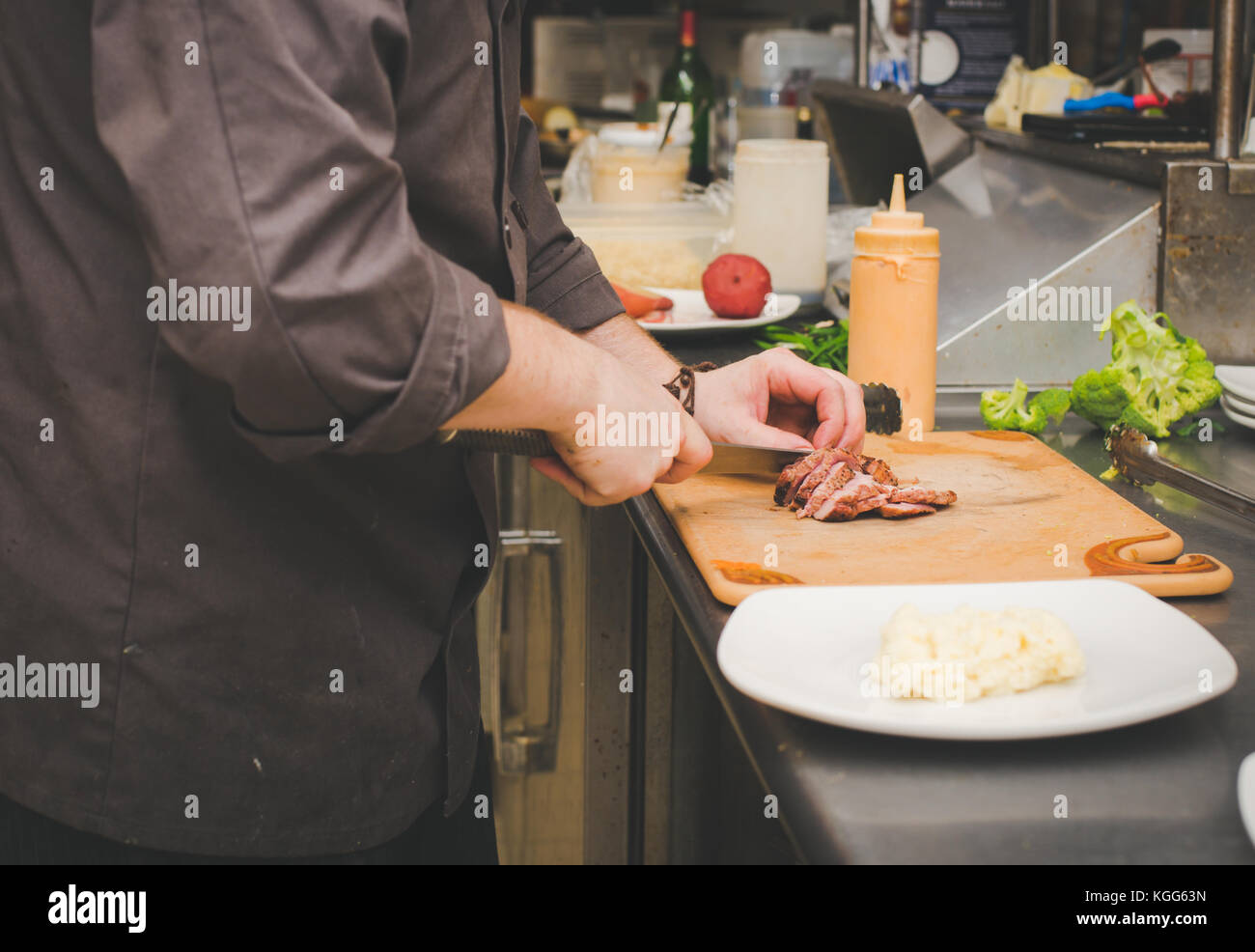 A chef prepares food in the kitchen of a restaurant Stock Photo