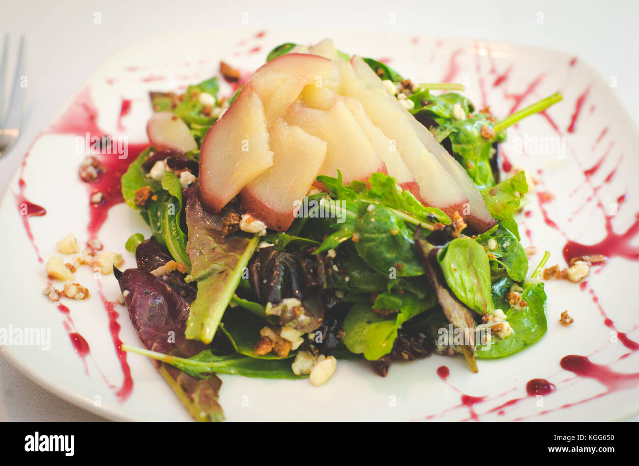 A salad with pears and produce on a plate in a restaurant. Stock Photo