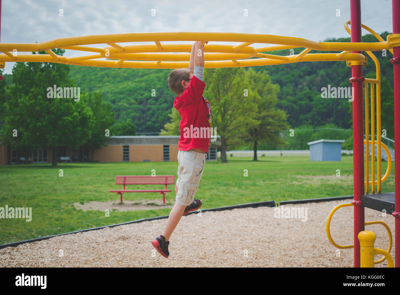 11-12 year old on climbing bars at a playground Stock Photo