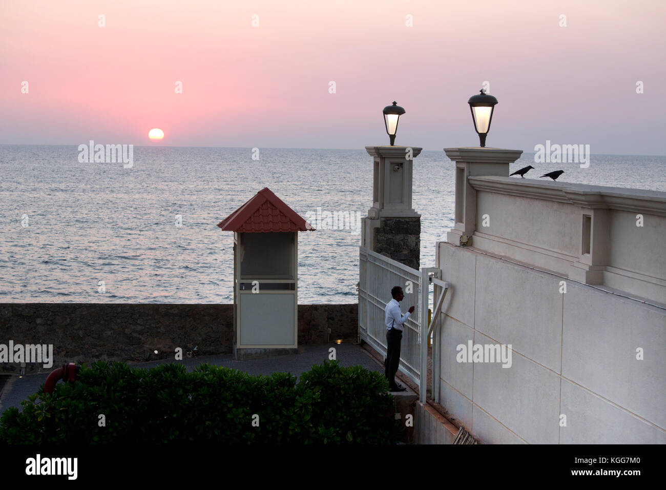 Colombo Sri Lanka Indian Ocean at Sunset security guard at gate of Galle Face Green Hotel Stock Photo