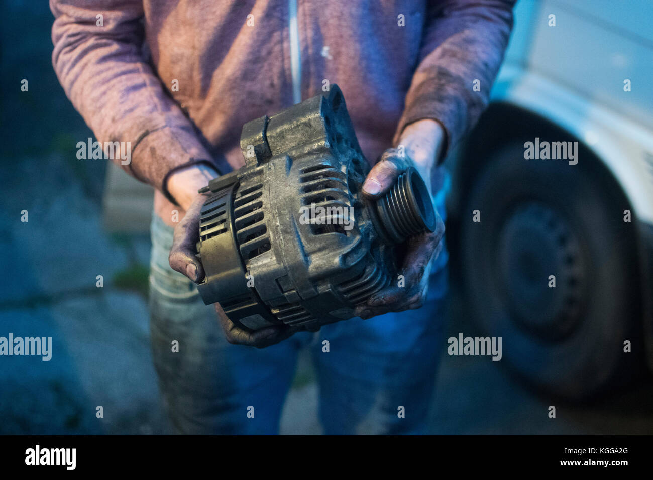 Broken alternator, held by oilcovered hands. Harriet Baggley October