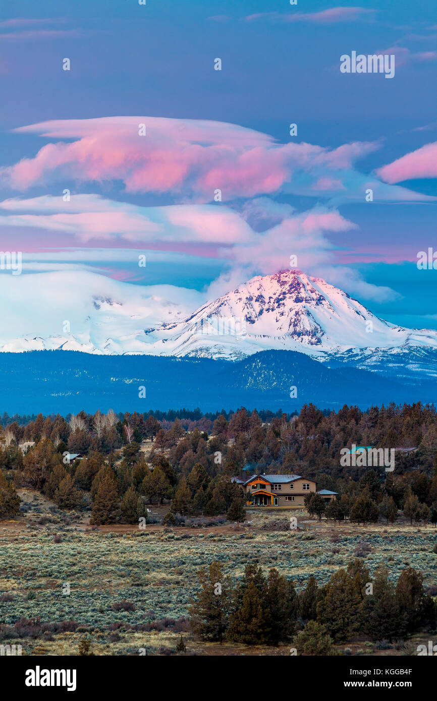 A Cabin Sits Below North Sister Mountain During A Colorful Winter