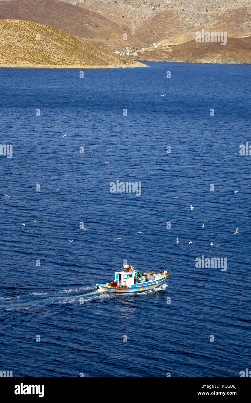 Blue and white fishing boat on blue sea with seagulls, Kalymnos, Greece ...