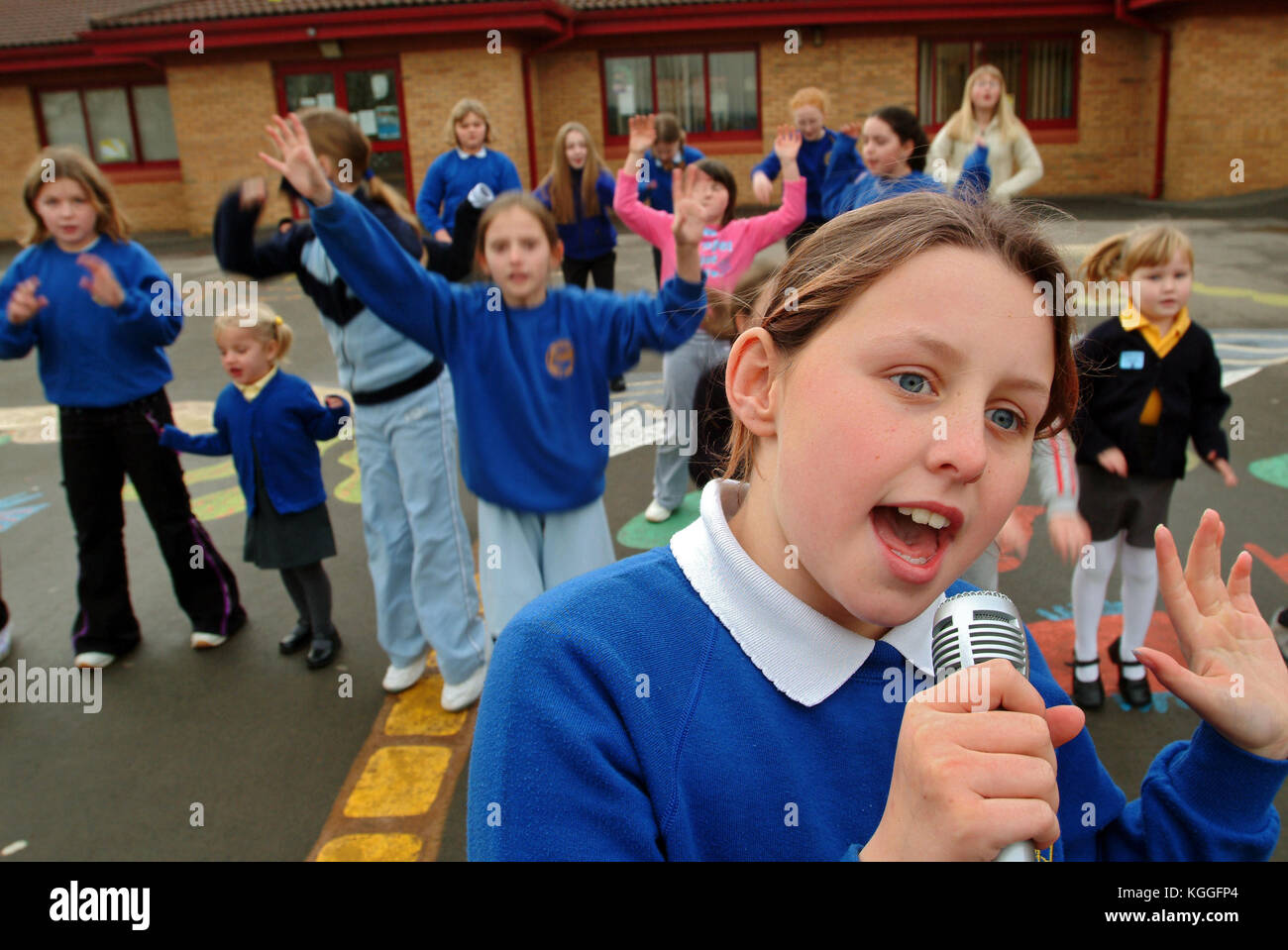 Penyrheol Primary School, Gorseinon, Swansea. Zoe Owens leads the routine with the karaeoke microphone for the lunchtime dance club. Stock Photo