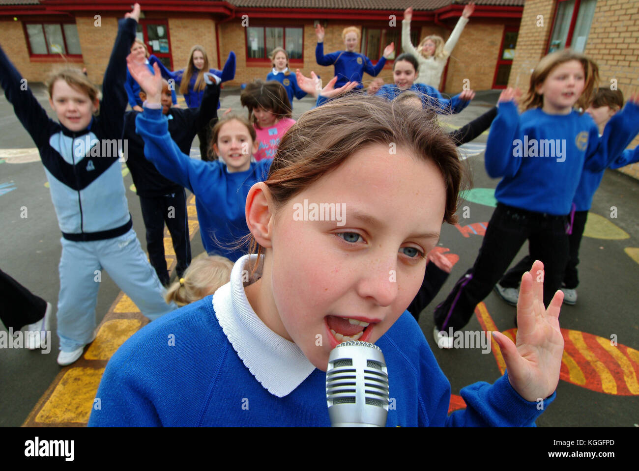 Penyrheol Primary School, Gorseinon, Swansea. Zoe Owens leads the routine with the karaeoke microphone for the lunchtime dance club. Stock Photo