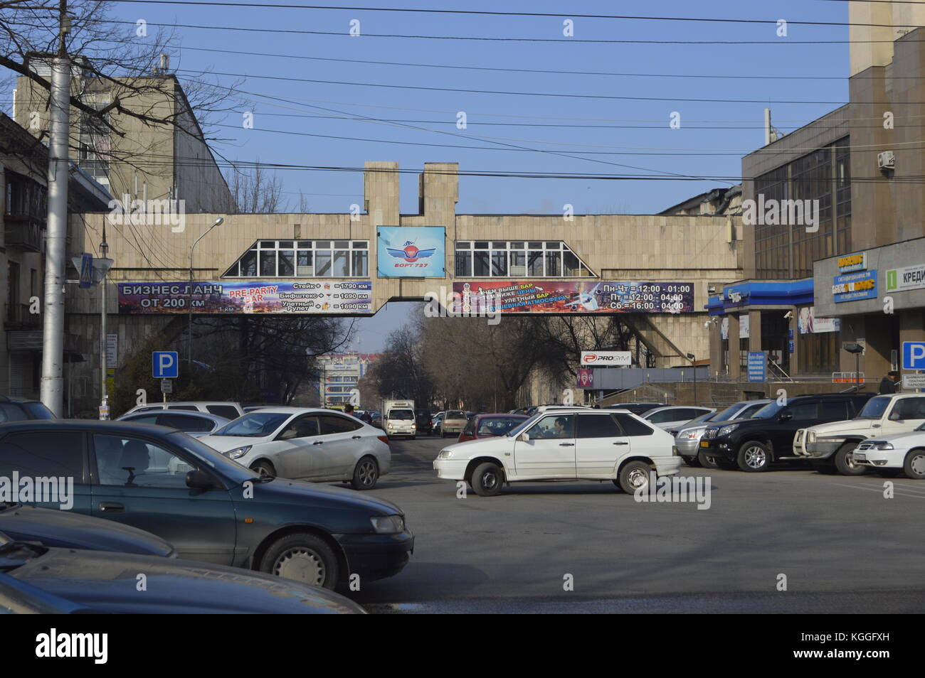 Pedestrian cross walk bridge from one building to another in concrete panels and monumental architecture in Almaty, Kazakhstan. Russian advertisement. Stock Photo