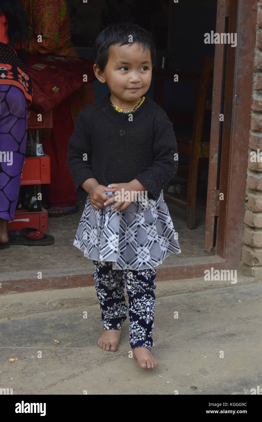 Little Nepalese girl with skirt and Bindi, Hindu dot, playing with hands in Panauti, nepal. Stock Photo