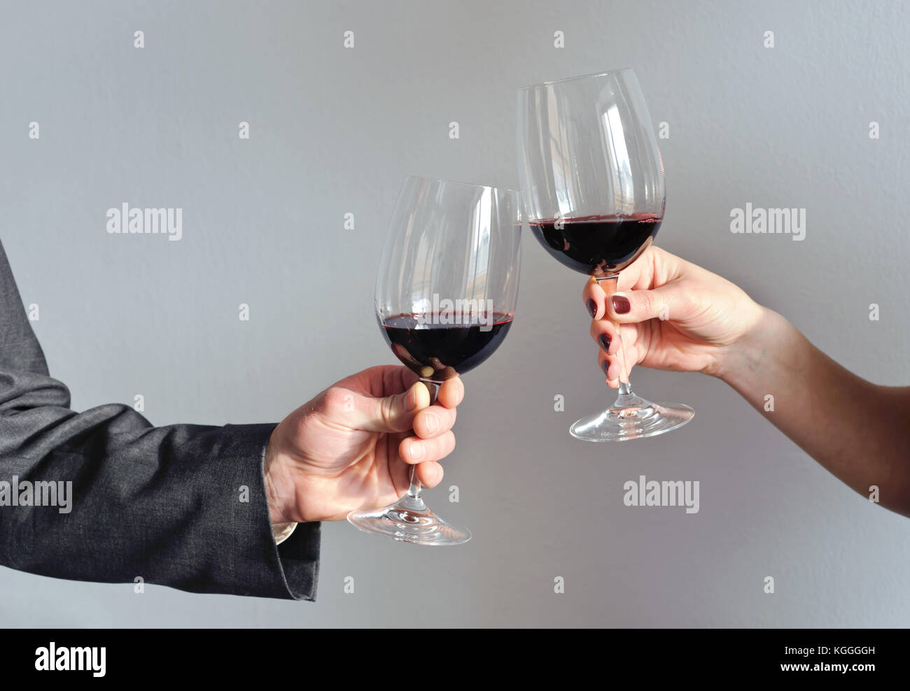 Male and female hands holding glasses with red wine Stock Photo