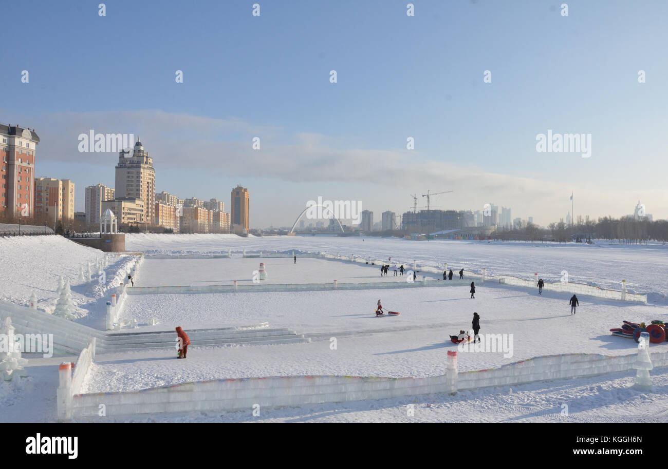 Ishim, Esil river is frozen and turned into an ice skating fun park. ice slide, Astana, capital of Kazakhstan. walking on the river, ice, water. Stock Photo