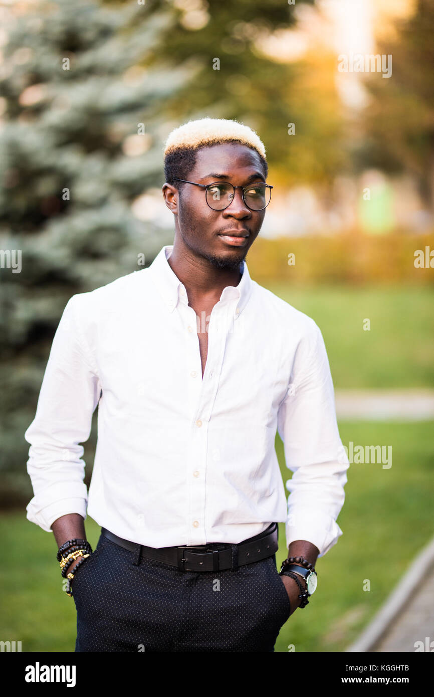 Portrait of young african man in white shirt style clothes on the city ...