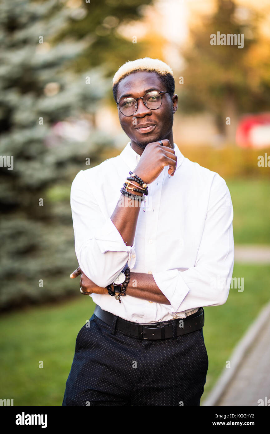Portrait of young african man in white shirt style clothes on the city ...