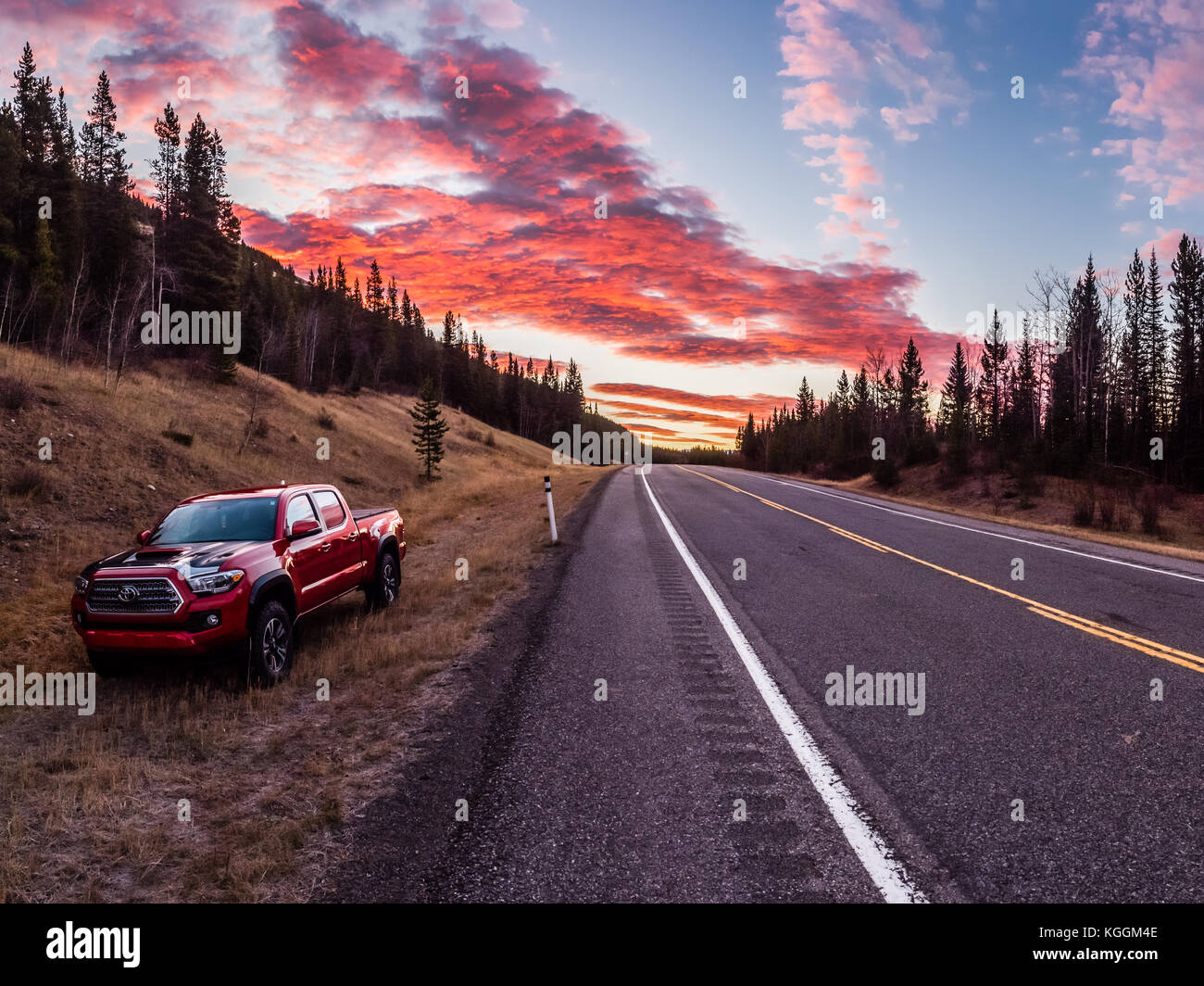 Toyota Tacoma Truck in Ditch with Brilliant Sunrise along a lonely Highway Stock Photo