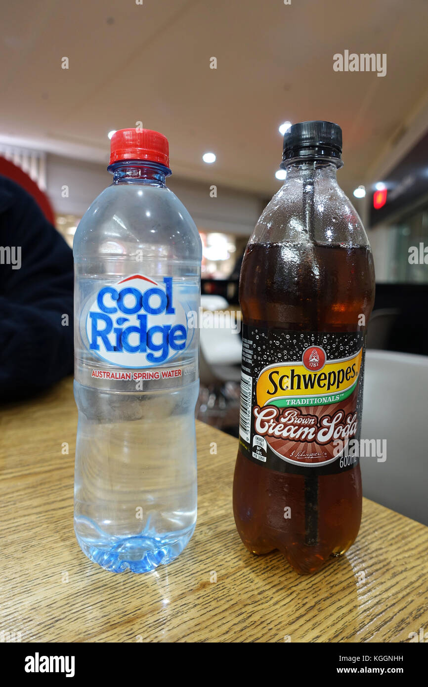 A bottle of Cool Ridge Water and Schweppes Brown Cream Soda  soft drink on wooden table Stock Photo