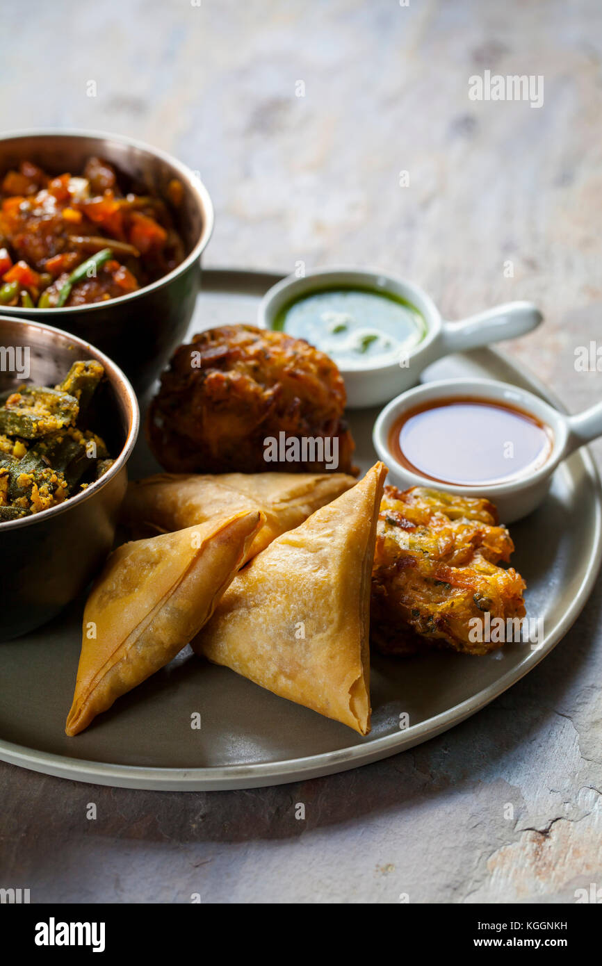 Selection of Indian dishes samosas, onion bhaji, manchurian balls and