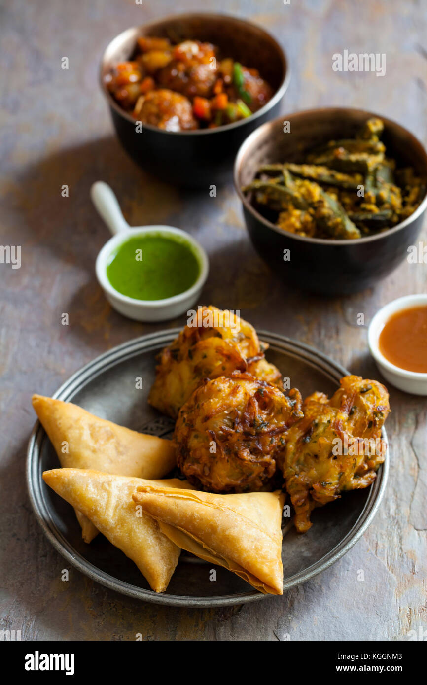 Selection of Indian dishes samosas, onion bhaji, manchurian balls and