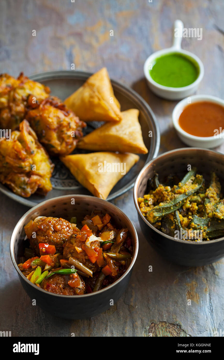 Selection of Indian dishes samosas, onion bhaji, manchurian balls and