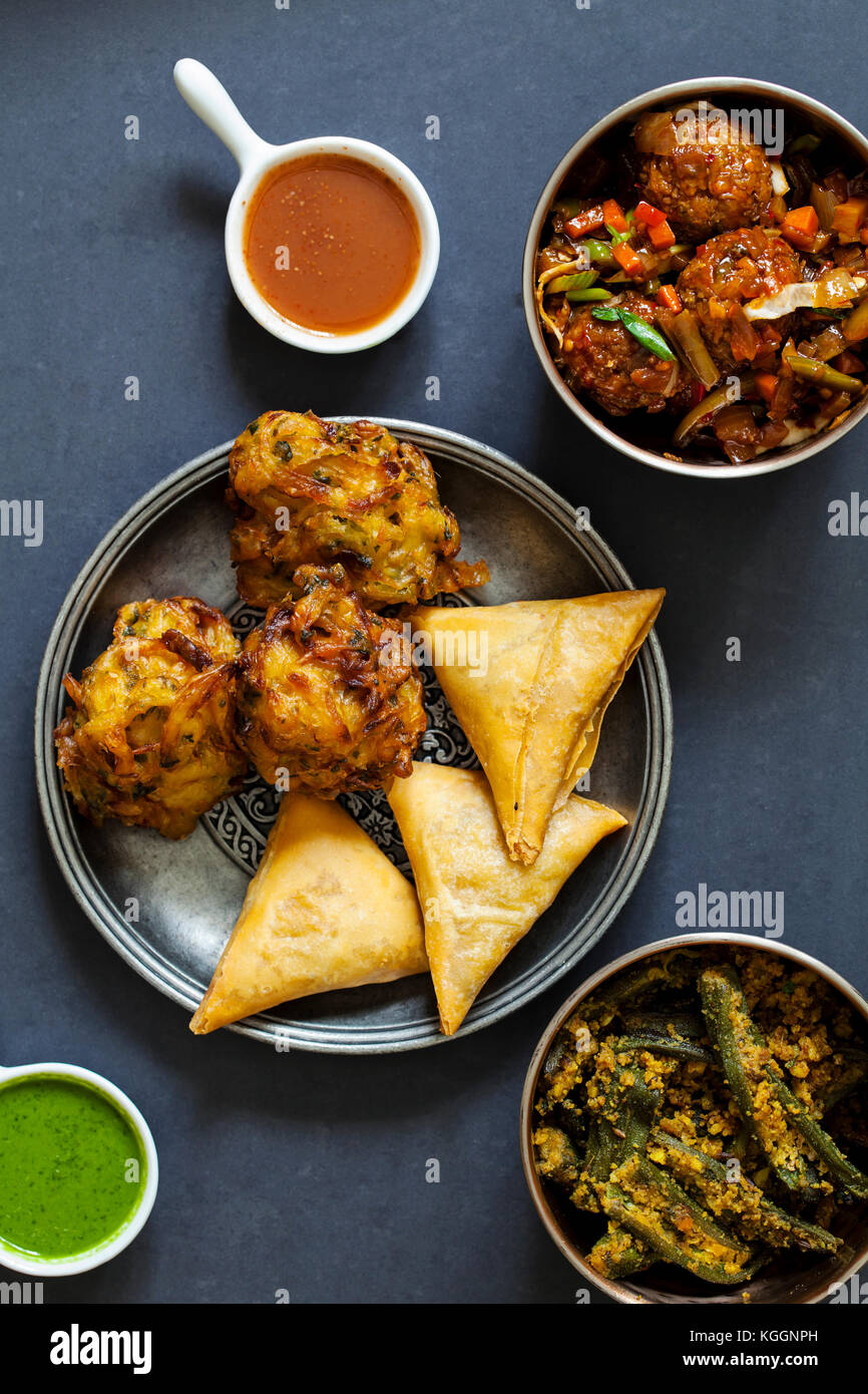 Selection of Indian dishes samosas, onion bhaji, manchurian balls and
