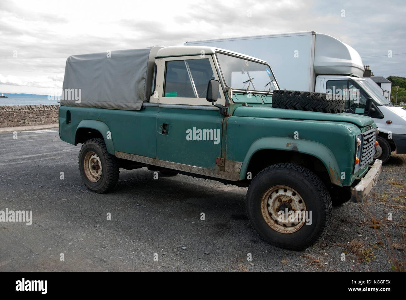 1980's Green White Land Rover Defender 110 Pick up Craighouse Isle of Jura Scotland front offside view of 1983 rusty green white land rover defender l Stock Photo