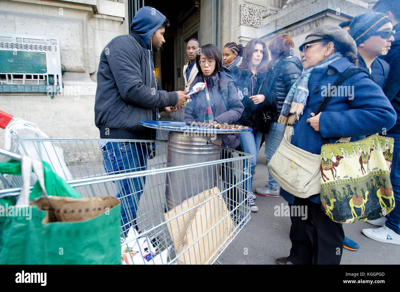 Paris, France. Man selling roasted chestnuts from a shopping trolly outside the Louvre Stock Photo