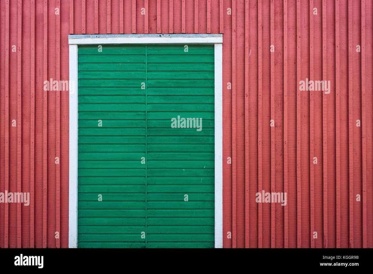 Green wooden door on a red wooden wall Stock Photo