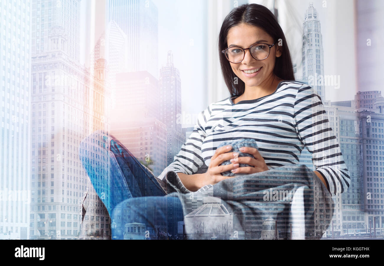 Happy young woman sitting and smiling cheerfully Stock Photo - Alamy
