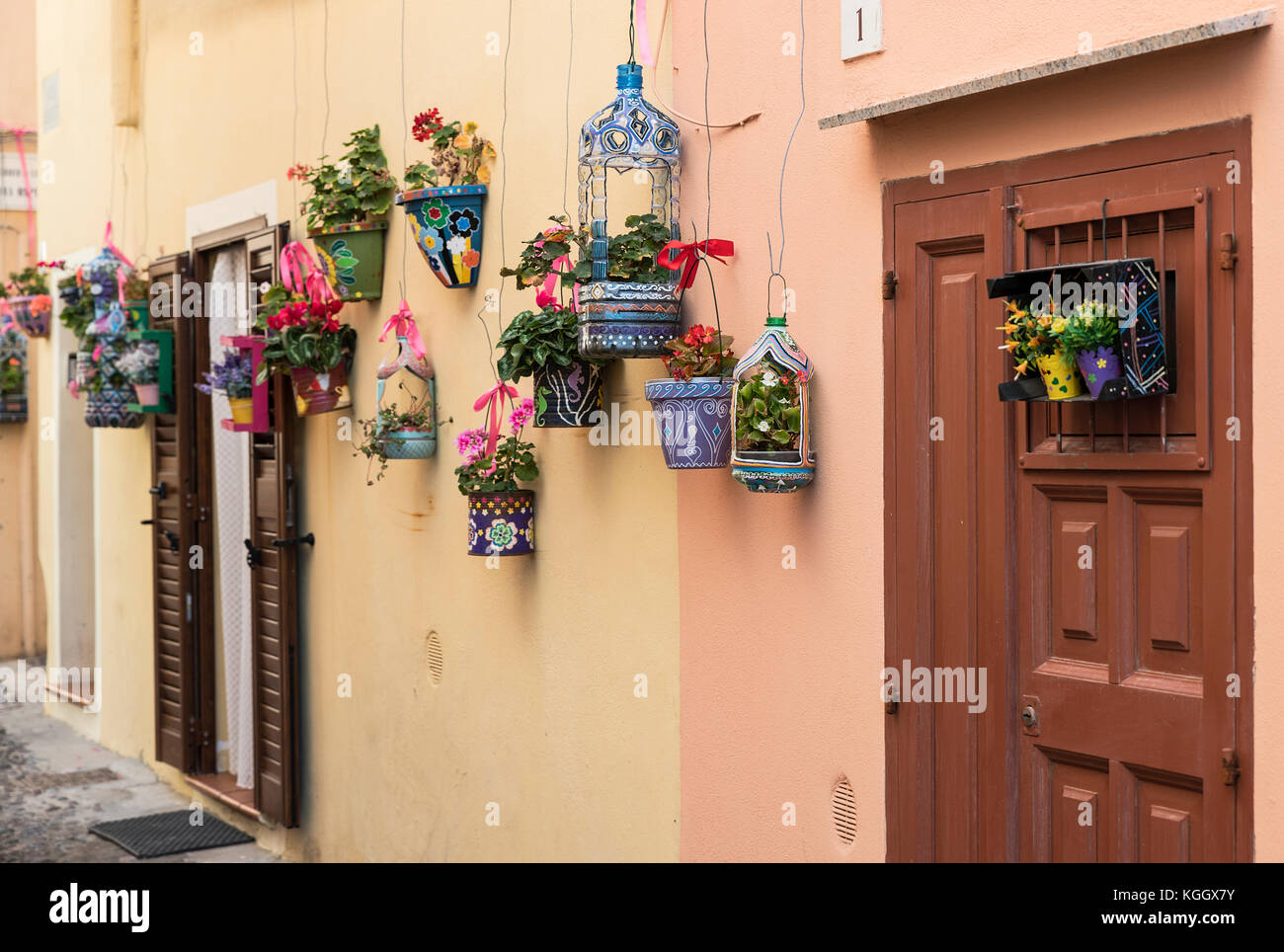 Hand painted planters and colorful flowers adorn a charming street,, Alghero,, Sardinia, Italy. Stock Photo
