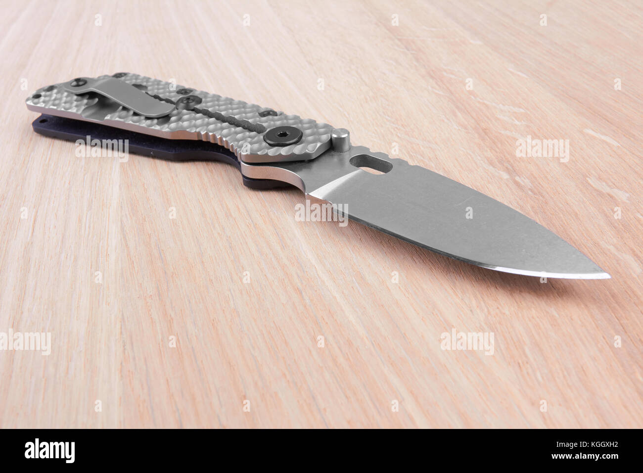 Folding knife on a wooden background Stock Photo - Alamy