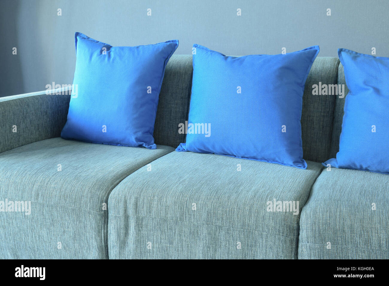 Blue color pillows setting on light blue sofa with blue wall Stock