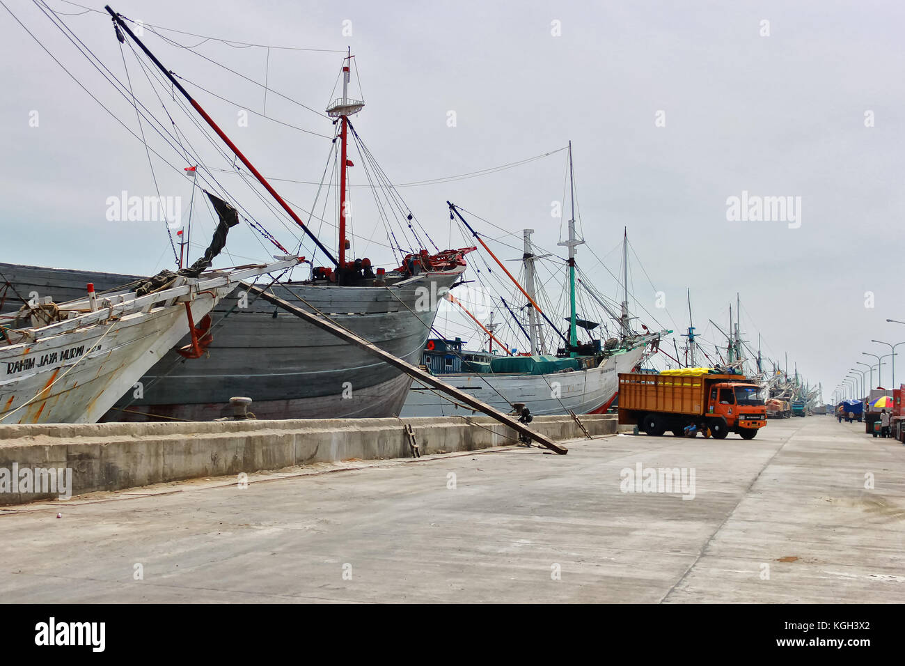 Phinisi ship in a harbor with trucks at the background in Jakarta, Indonesia. Stock Photo