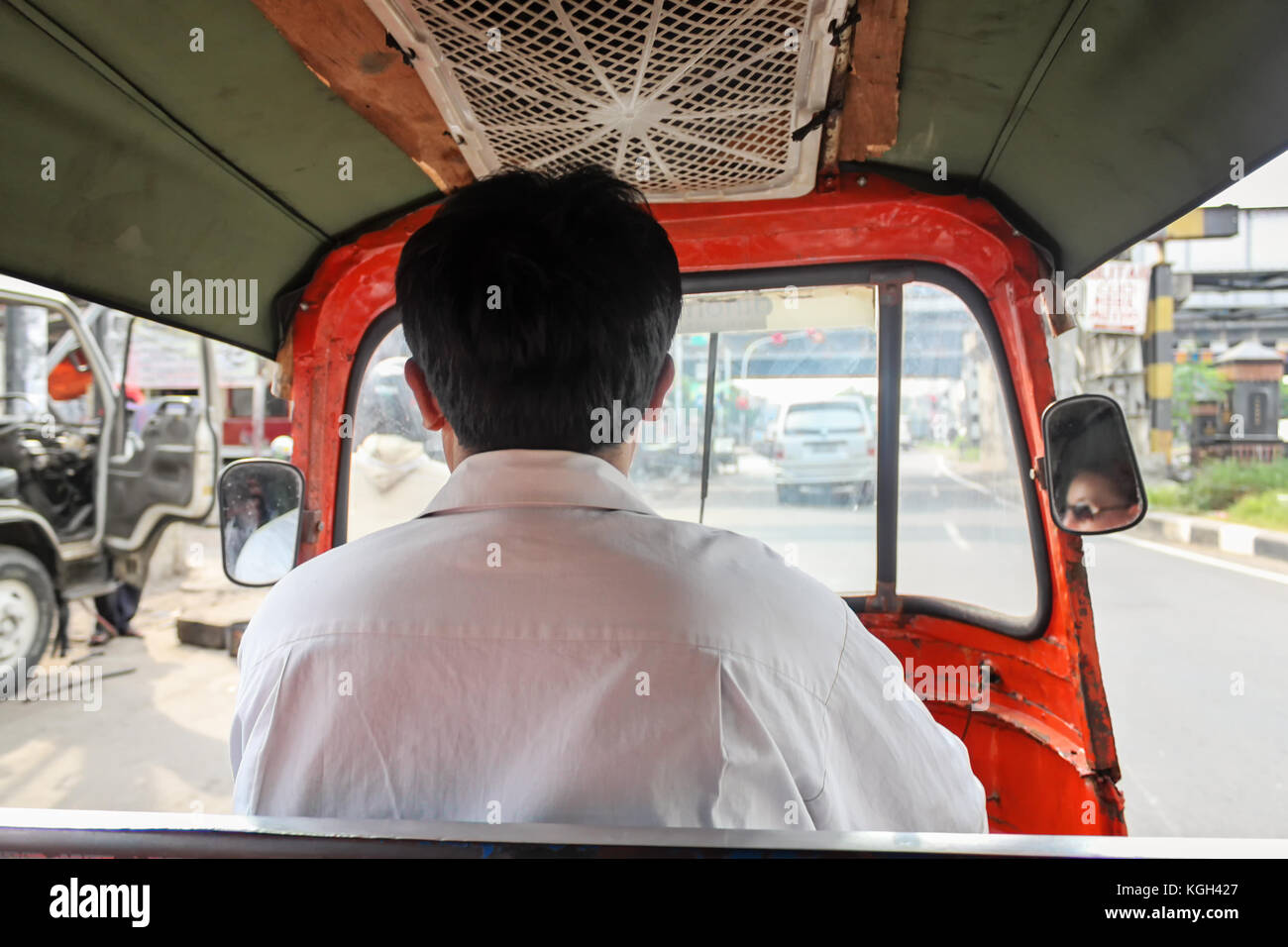 Driver driving tuk tuk - auto rickshaw , small vehicle typical for Jakarta, Indonesia Stock Photo