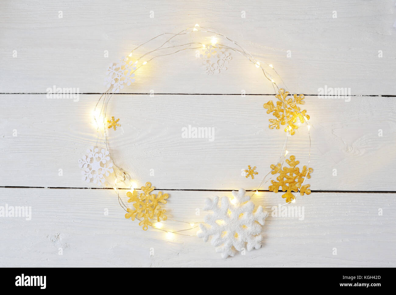 Christmas wreath of snowflakes and garlands on a white wooden