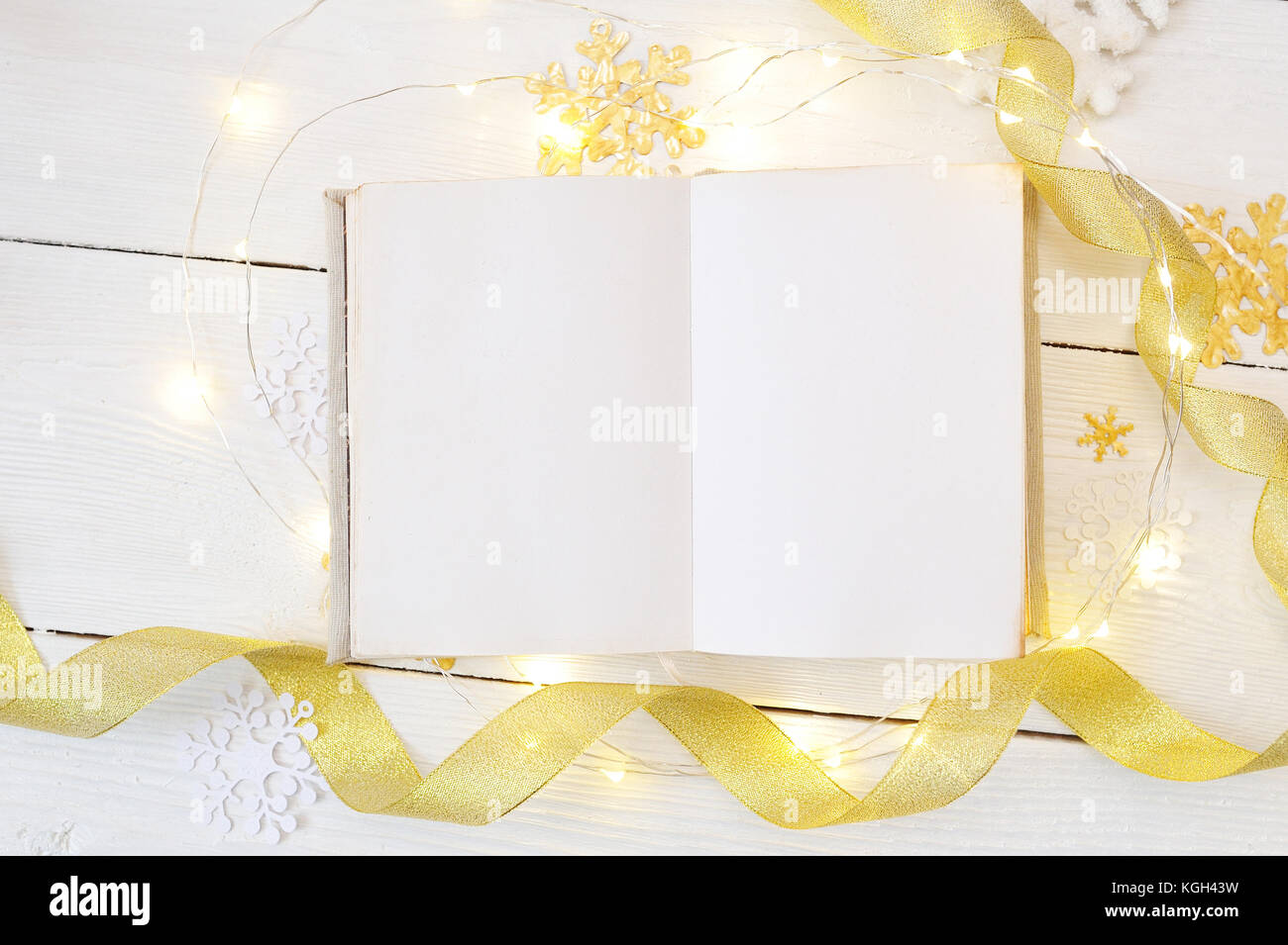 Mockup christmas or new year frame composition. mockup of book and golden christmas decorations on wooden background. holiday and celebration concept for postcard or invitation. top view Stock Photo