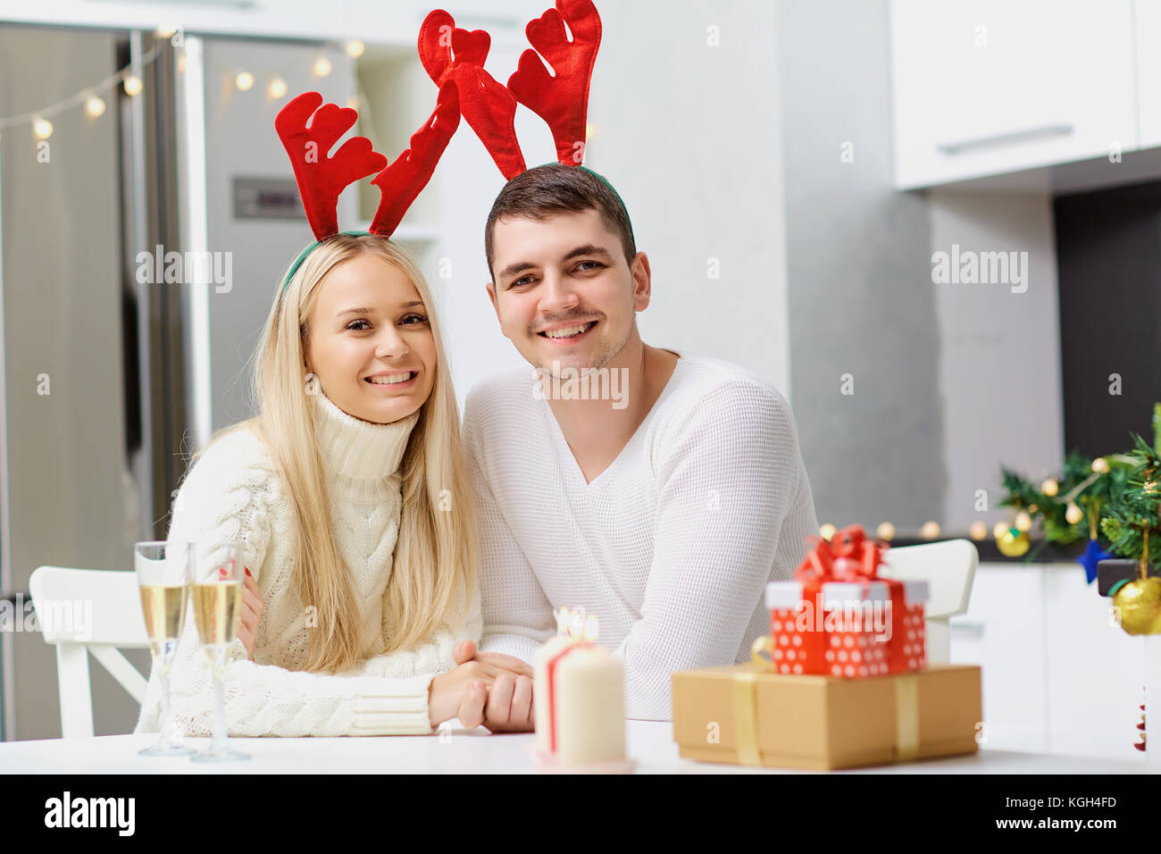 Couple in reindeer horns gives a Christmas present. Stock Photo
