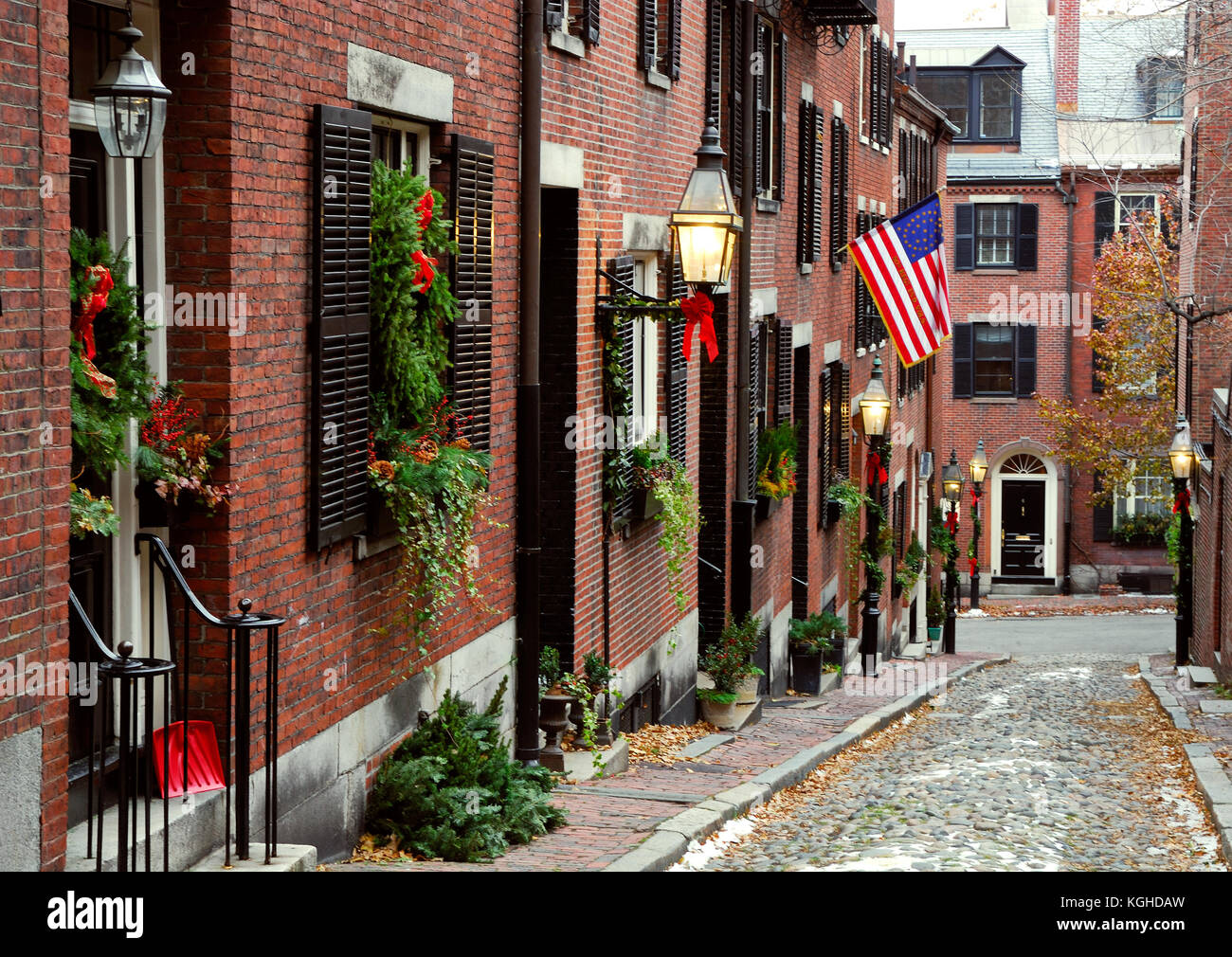 Historic Acorn Street in Beacon Hill, Boston. Christmas decorations, historic American flag, cobblestone pavers, street lamps. Stock Photo