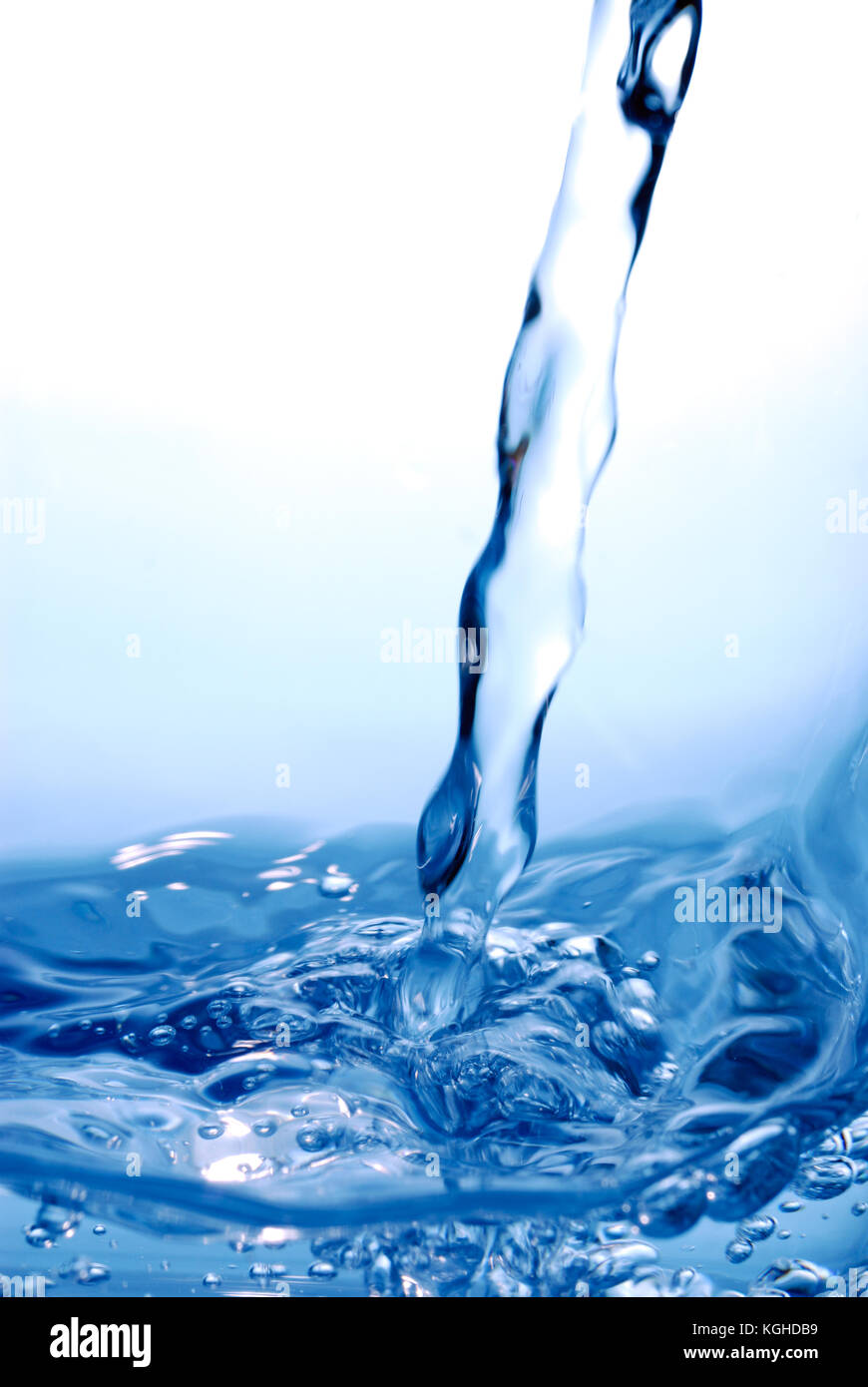Free flowing water stream and splash. Wavy water surface isolated on blue. Fresh and dynamic abstract background. Stock Photo