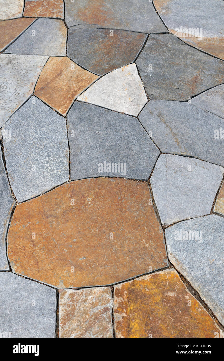 Natural stone pavers in irregular pattern. Colorful footpath, patio background Stock Photo