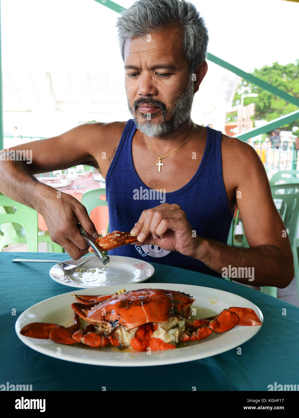 A tourist enjoying a female crab with her eggs. Stock Photo