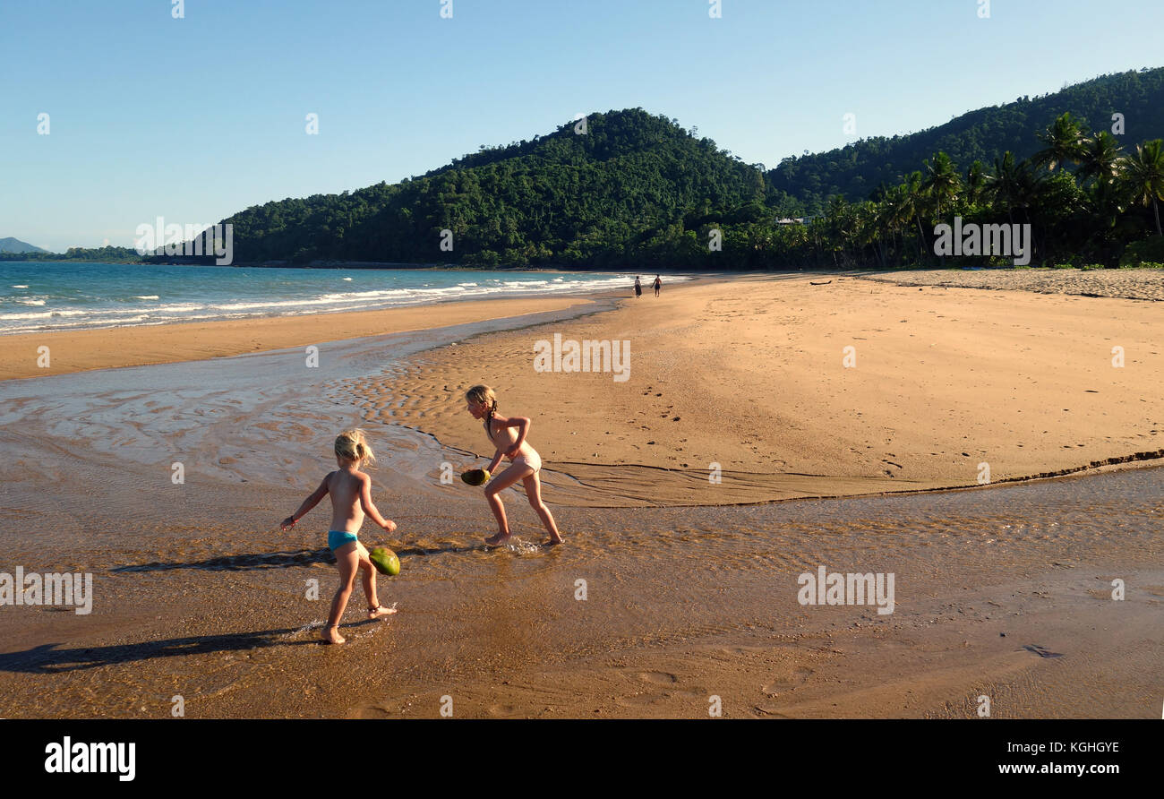 Kids playing with coconuts in freshwater creek, Bingil Bay, Mission