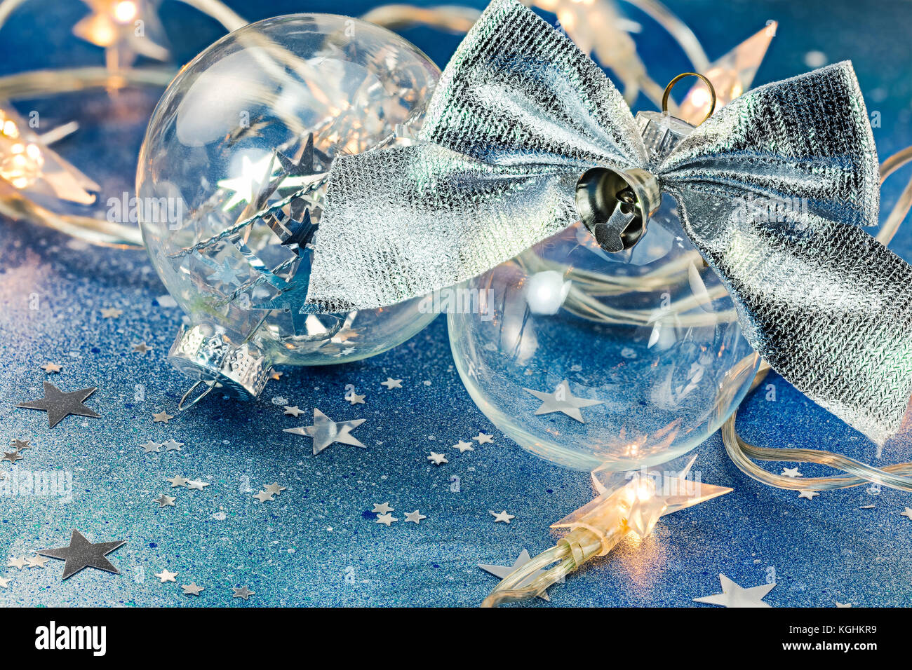 christmas tree balls with silver bow and holiday lights on blue glitter ...