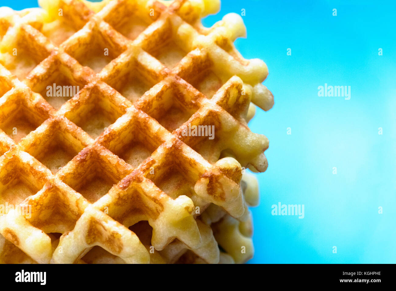 overview of a fleshly baked Belgium waffles showing a blue background for copy space such as menus, recipes and text Stock Photo