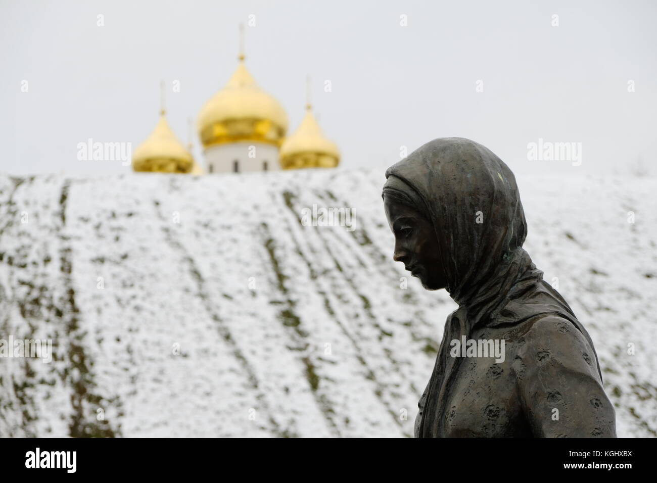 Woman in scarf in front of the domes of the Dormition Cathedral - Dmitrov Kremlin, Moscow Region, Russia Stock Photo
