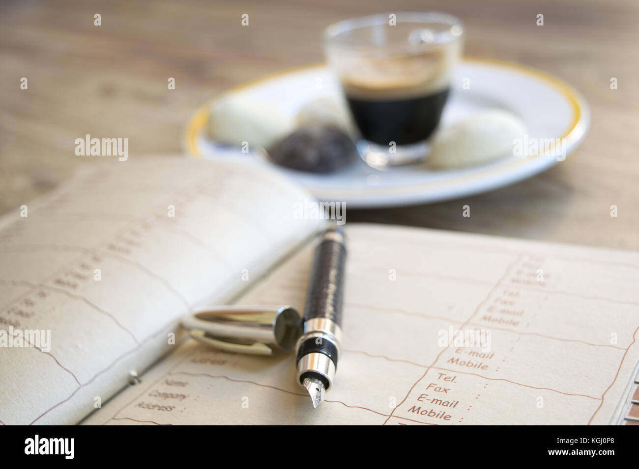 concept of business with an espresso coffee on a diary with money and a stylograph Stock Photo