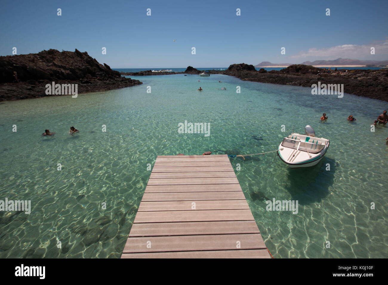 Overlook view from the dock of Los Lobos Islet, with people swimming in the transparent waters. Fuerteventura, Spain. Stock Photo