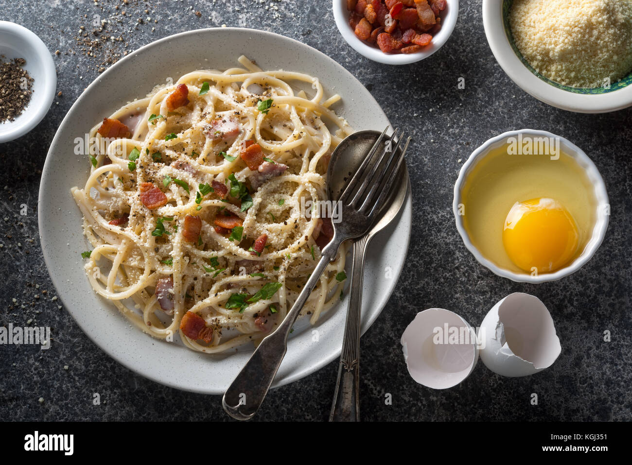 A plate of delicious pasta carbonara with fettuccine, bacon, parsley, parmesan cheese and egg. Stock Photo