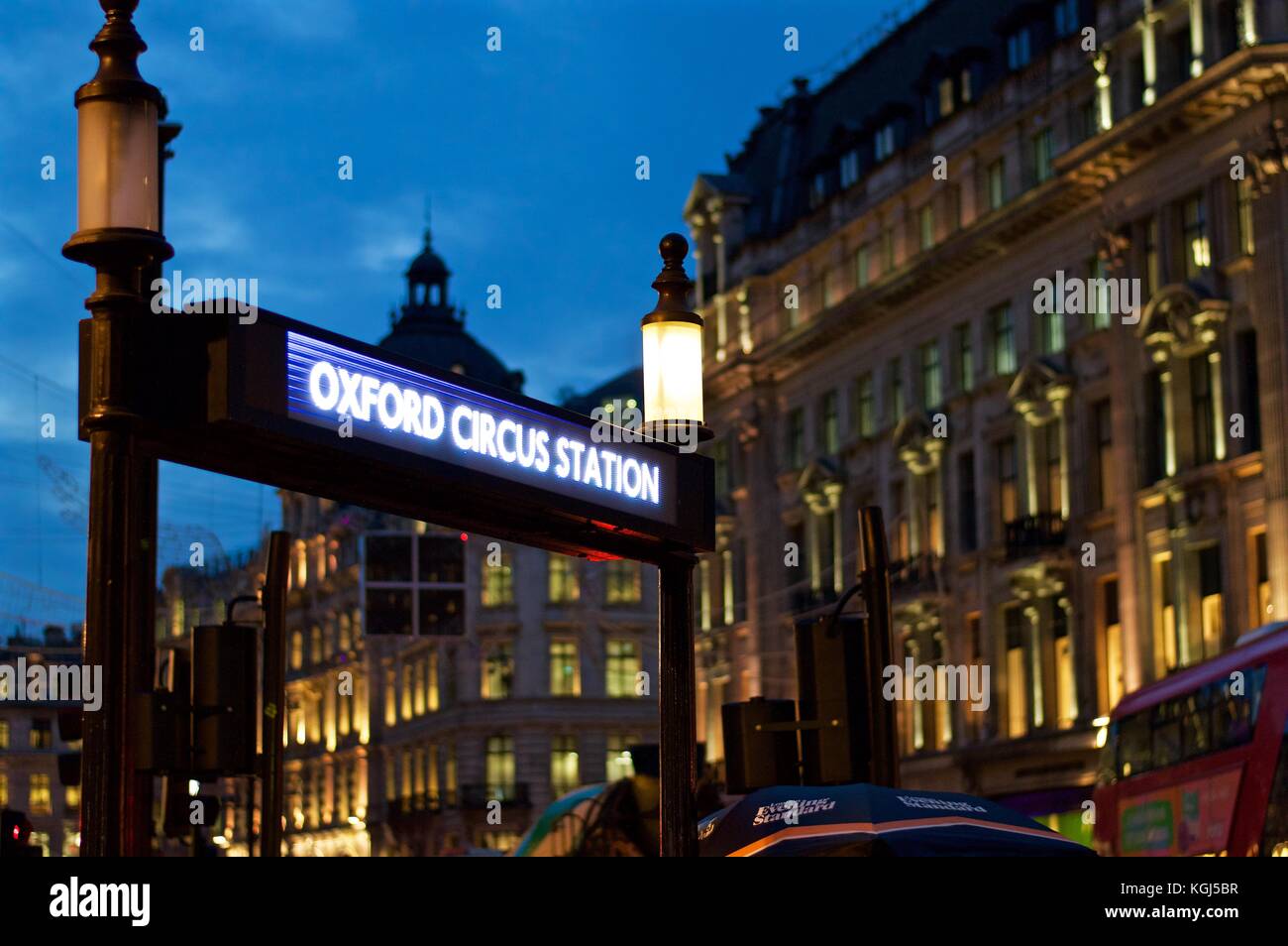 Oxford Circus Tube Station sign with Regent Street buildings in the background, night, London, UK Stock Photo