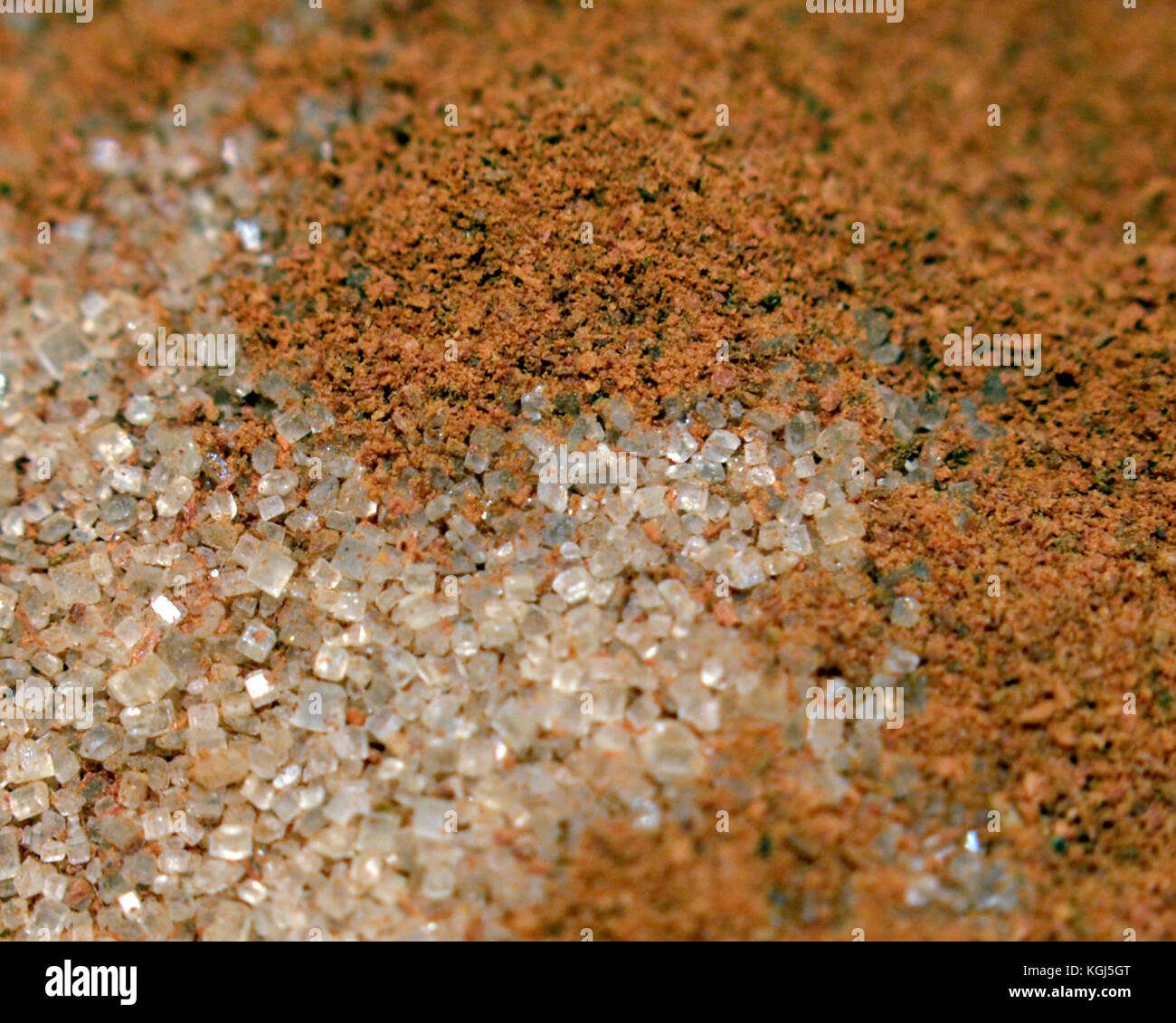 Cinnamon powder on top of white sugar granules. Stock Photo